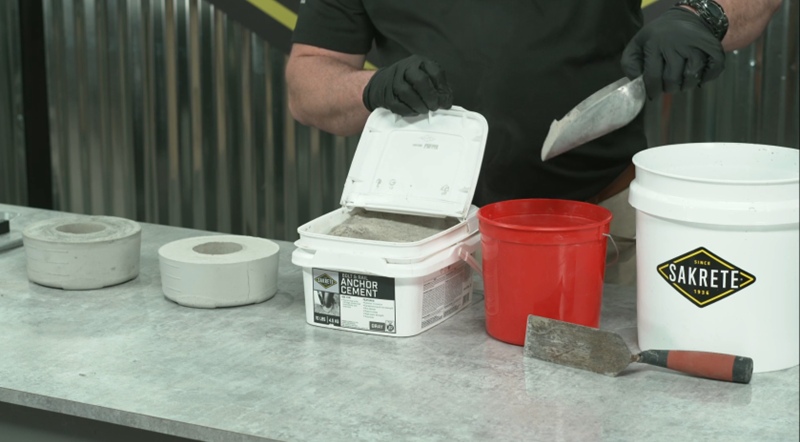 Man using Sakrete anchor cement