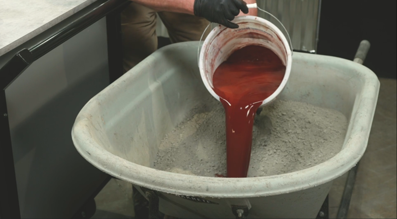 Adding color to wheelbarrow of Sakrete Concrete mix